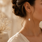 Close-up of the Maristelle Pearl Drop Earrings and graceful gold silhouette