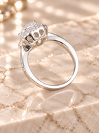 Rear profile of the Lumière Ring showing the open gallery beneath the emerald-cut center and halo setting