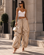 Maison Bragga Veyra sculpt parachute pants in Sand Beige styled with white lace top and heels