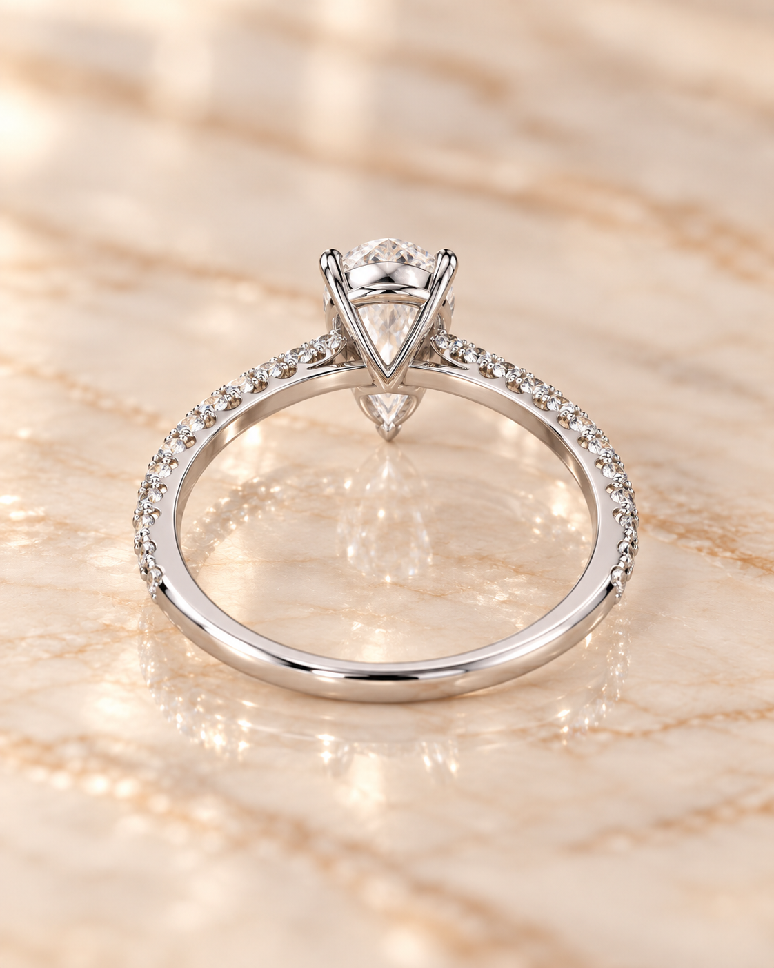 Profile view of the Seraphine Diamond Ring showing the raised pear-cut setting and pavé shoulders
